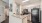 a kitchen with marble counters and a black refrigerator